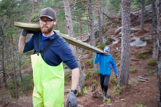 Vegard Bendiksen (t.v.) sammen med Marius Jansen Grønvold på vei inn i skogen med en ny trapp.