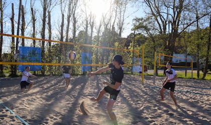 Søgne Volley spiller volleyball i solskinn.