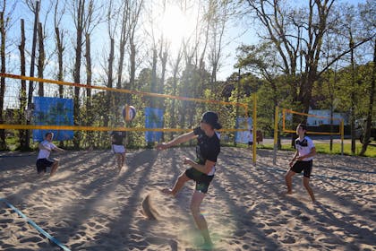 Søgne Volley spiller volleyball i solskinn.