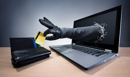 Stealing a credit card through a laptop concept for computer hacker, network security and electronic banking security