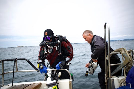 Jan Kristoffersen får hjelp av dykkerkollega Glenn Ivar Tønnessen med å komme opp i båten