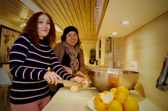 Nafiseh Josefi og Nourieh Behrouzi steller i stand lunsj på kjøkkenet, som er finansiert gjennom Lokalbankfondet.